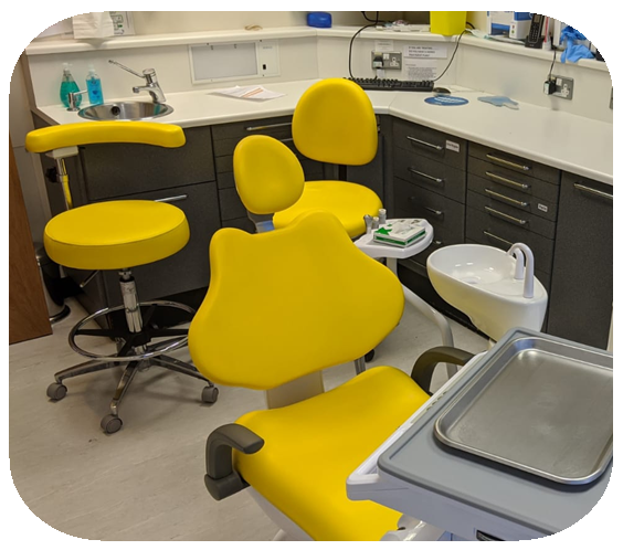 Dental office with yellow chairs and dental equipment.